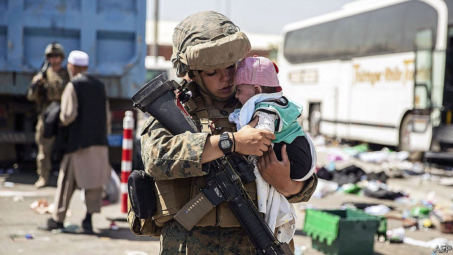 Image of a female Western soldier in field uniform holding a baby.